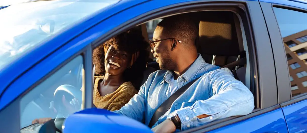 Casal feliz alugando carro.