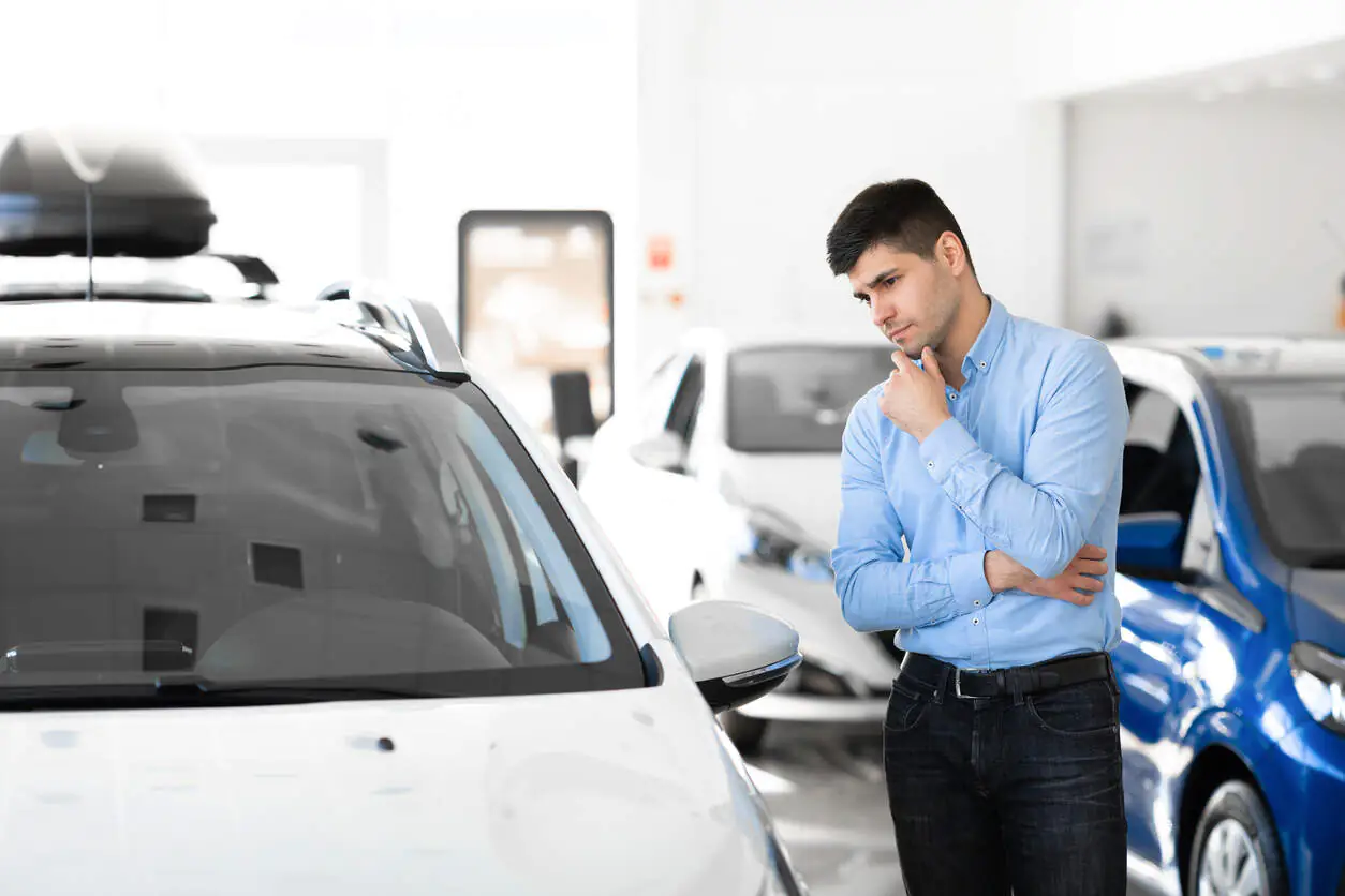 homem parado olhando para carro